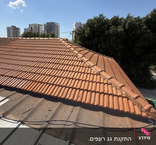 גג רעפים עם אדם עובד על תיקון
